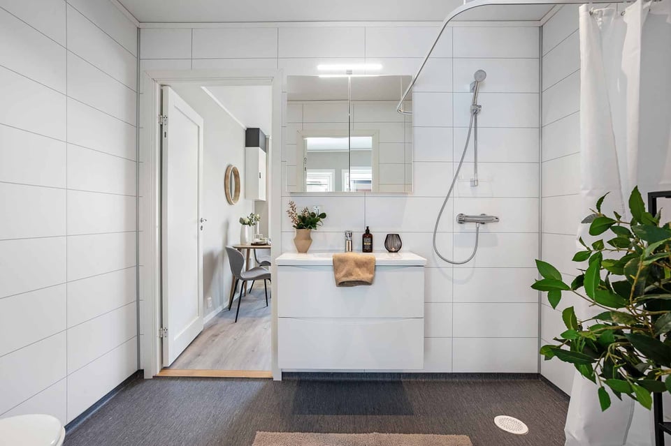 ruime badkamer met wastafel en douche in modulaire woning van Adapteo